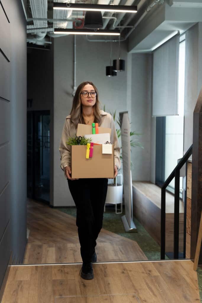 Relocation Consultant waking through office hallway with box in hands