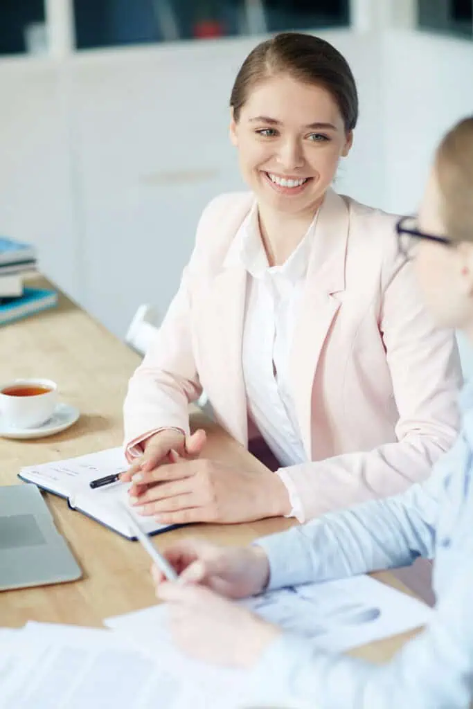 Co-workers talking over papers spread on papers