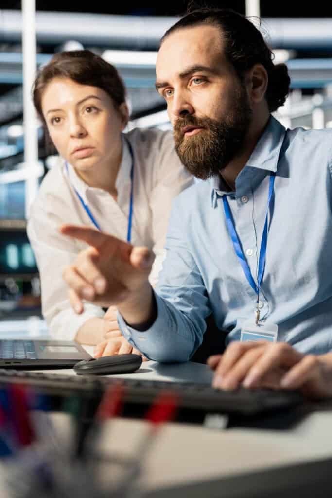 Sourcing services experts discussing work showing on computer