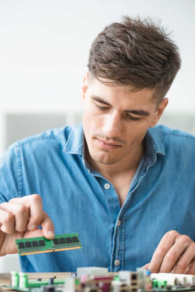 Male technician installing ram on the computer motherboard