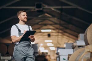 Young man holding a clipboard working at a factory