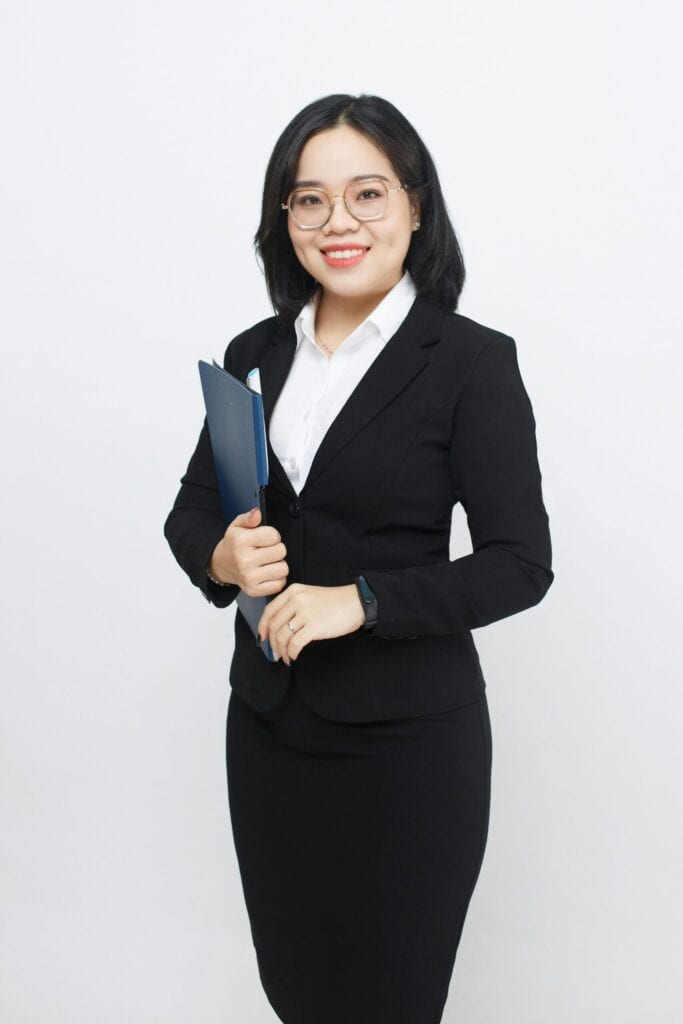 Interim CFO wearing a suit standing with a file in her hands, smiling